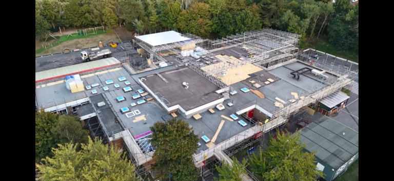 Aerial view of temporary-roof structures and scaffold access at Canford Heath schools in Poole