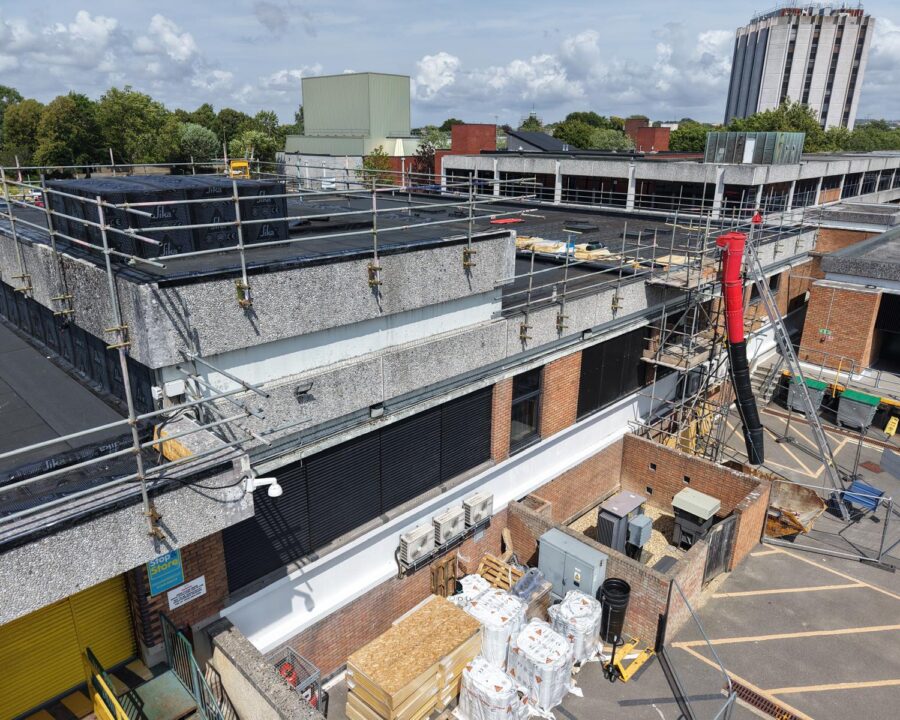 Roof-edge guardrails above a shopping-centre service yard