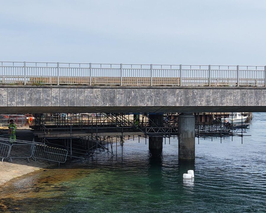 Suspended access scaffolding beneath Ferry Bridge in Weymouth, viewed from the water’s edge