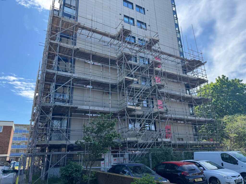 Scaffold platforms along a reclad residential elevation at Project Admiral in Poole