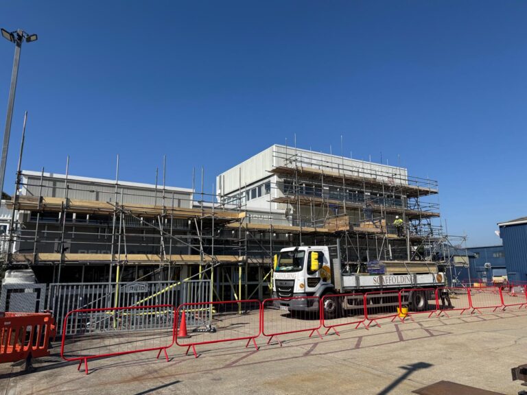 Independent access scaffolding along the REIDsteel HQ frontage in Christchurch, with TWK lorries on site